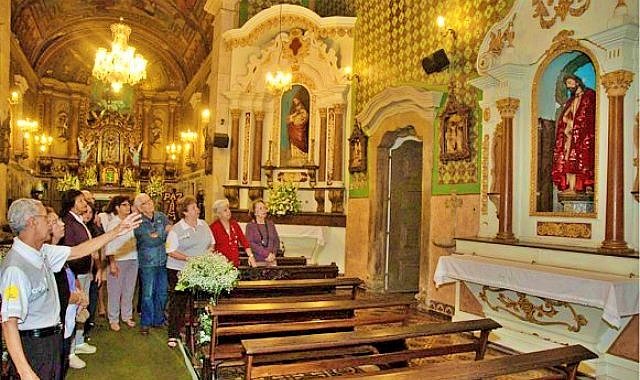 Idoso do programa Vovô Sabe Tudo monitora turistas em igreja de Santos, SP