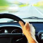 Motorista dirigindo um carro em estrada para Aparecida ou a Canção Nova, destinos de turismo religioso