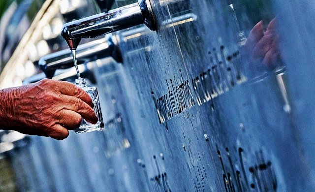 Peregrino enche vidrinho com água da fonte da Gruta das Aparições do Santuário de Lourdes - foto Eric Martin OTL