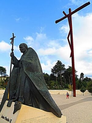 Estátua de São João Paulo II e a Cruz Alta, no Sntuário de Fátima, em Portugal - foto Mister No