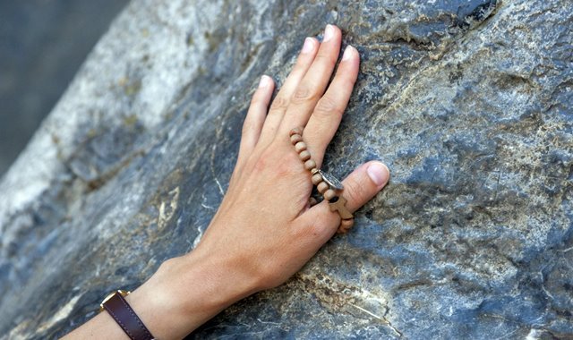 Devoto toca a rocha da Gruta das Aparições, no Santuário de Lourdes, na França - Foto Pierre Vincent