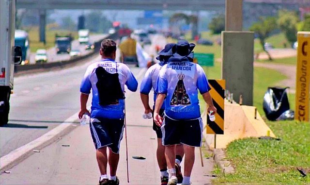 romeiros caminham no acostamento da Via Dutra rumo a Aparecida