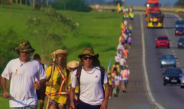Grupo de romeiros caminhando no acostamento da Via Dutra rumo a Aparecida