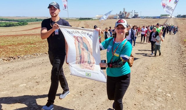 Participantes da 70a. edição da Rota da Fé caminham com banner de Nossa Senhora de Guadalupe