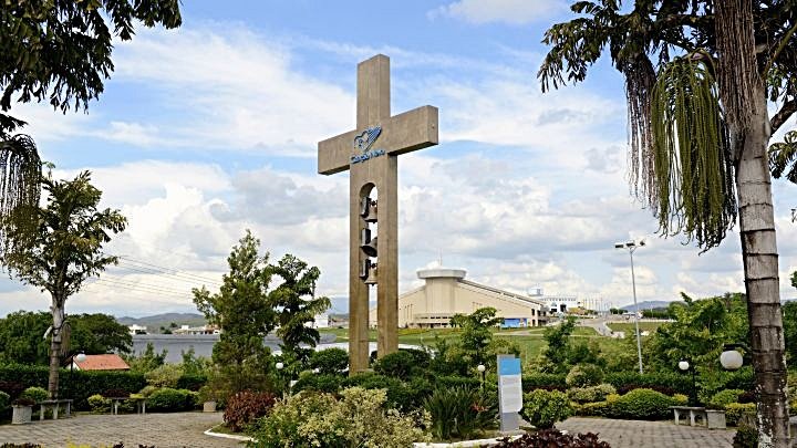 Cruzeiro na entrada da Canção Nova e, ao fundo, o Santuário do Pai das Misericórdias, em Cachoeira Paulista, erto de Aparecida–SP