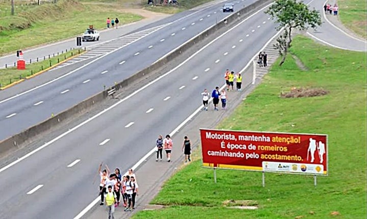 Pessoas caminam pelos perigosos acostamentos da Via Dutra para ir a Aparecida - reprução portalR3